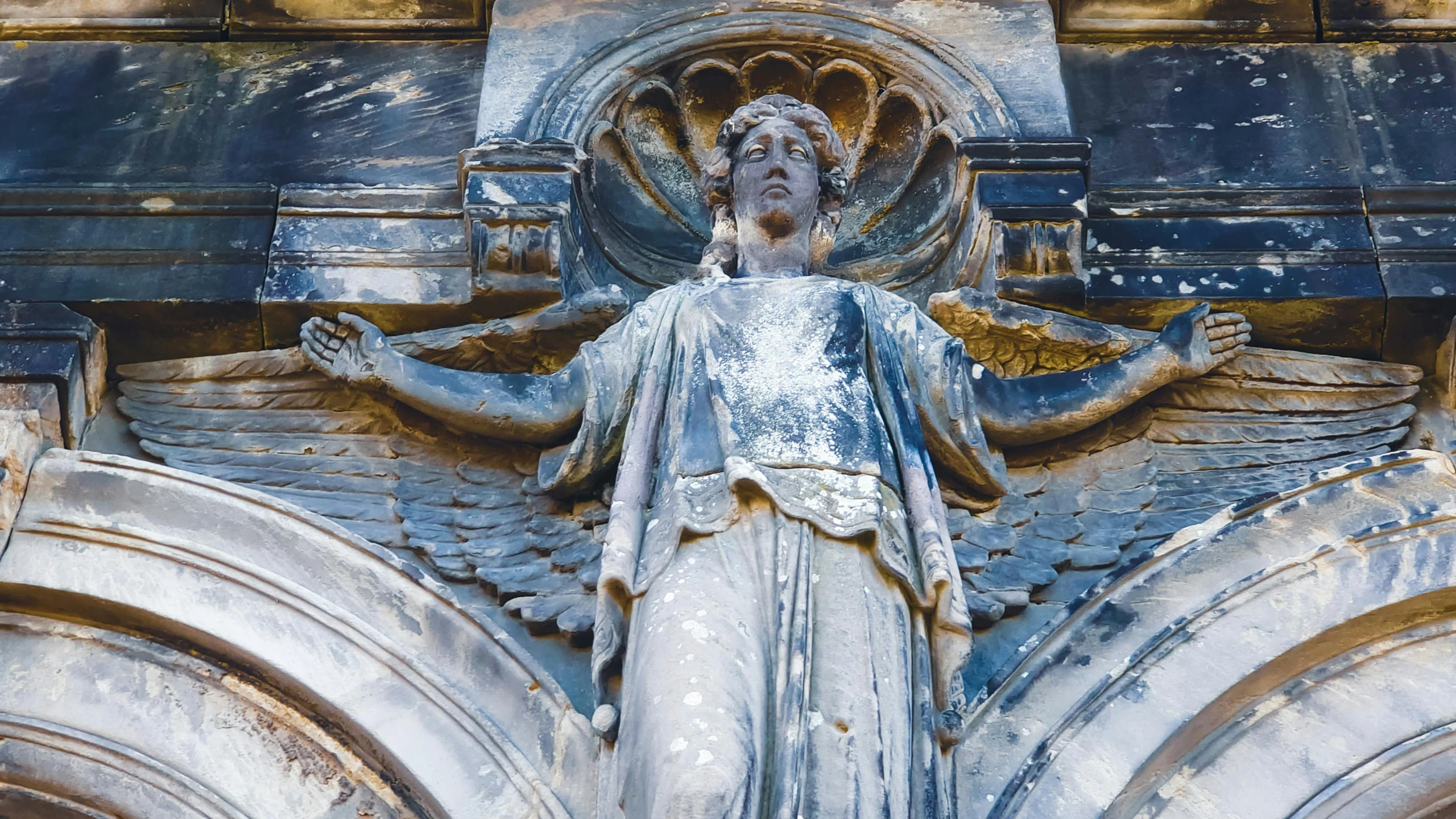 a statue is displayed on the facade of an old church