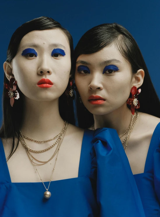 two women with make - up and blue makeup posing for a pograph