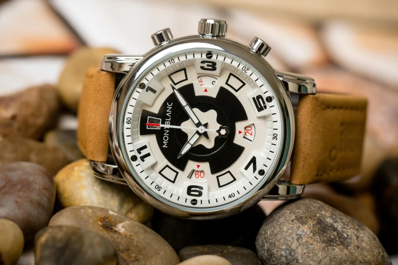 a watch is surrounded by rocks and other stones