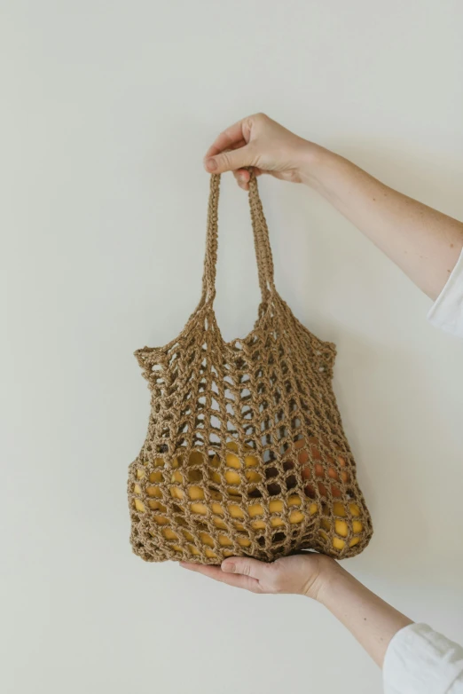 someone holding onto a handmade net bag