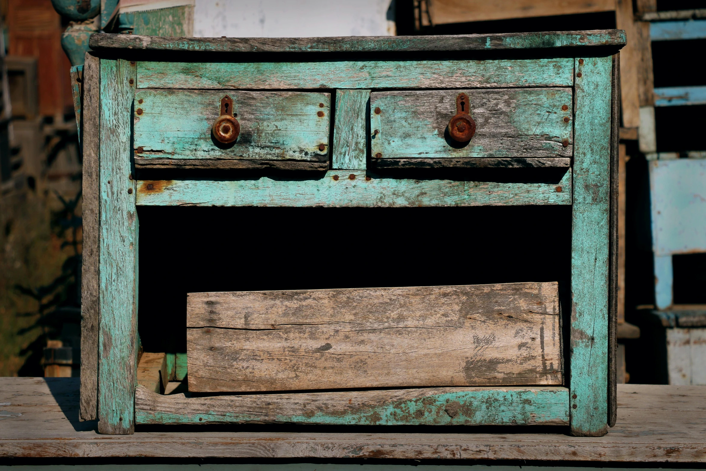 a green and worn chest of drawers with the doors open