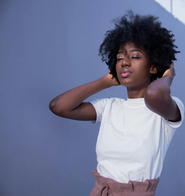 young black woman with curly hair posing for po