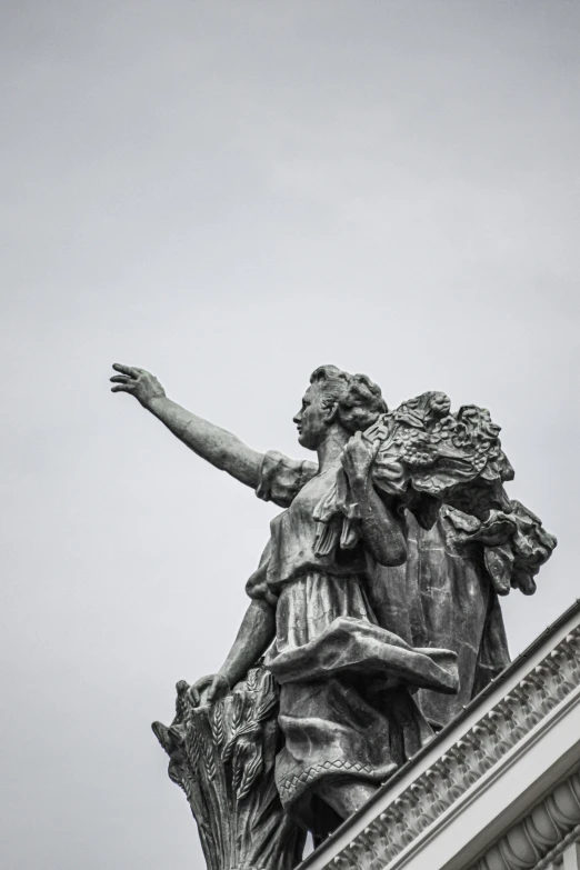 a statue on top of a building with an eagle flying overhead