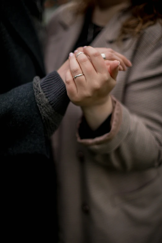 a couple are standing holding hands and touching each other
