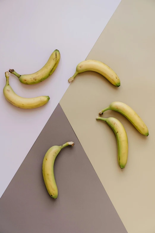 four banana are shown on a color block with two separate images, one of them has a yellow banana and the other a green banana