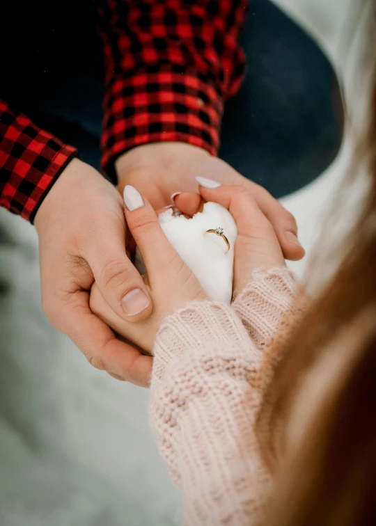 two hands on each other with a red and black shirt