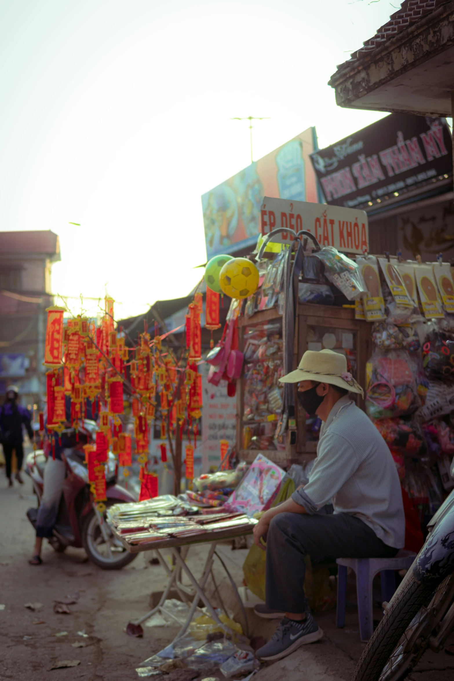 a woman sits at an outside market with food