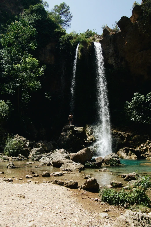 a man is standing near a waterfall