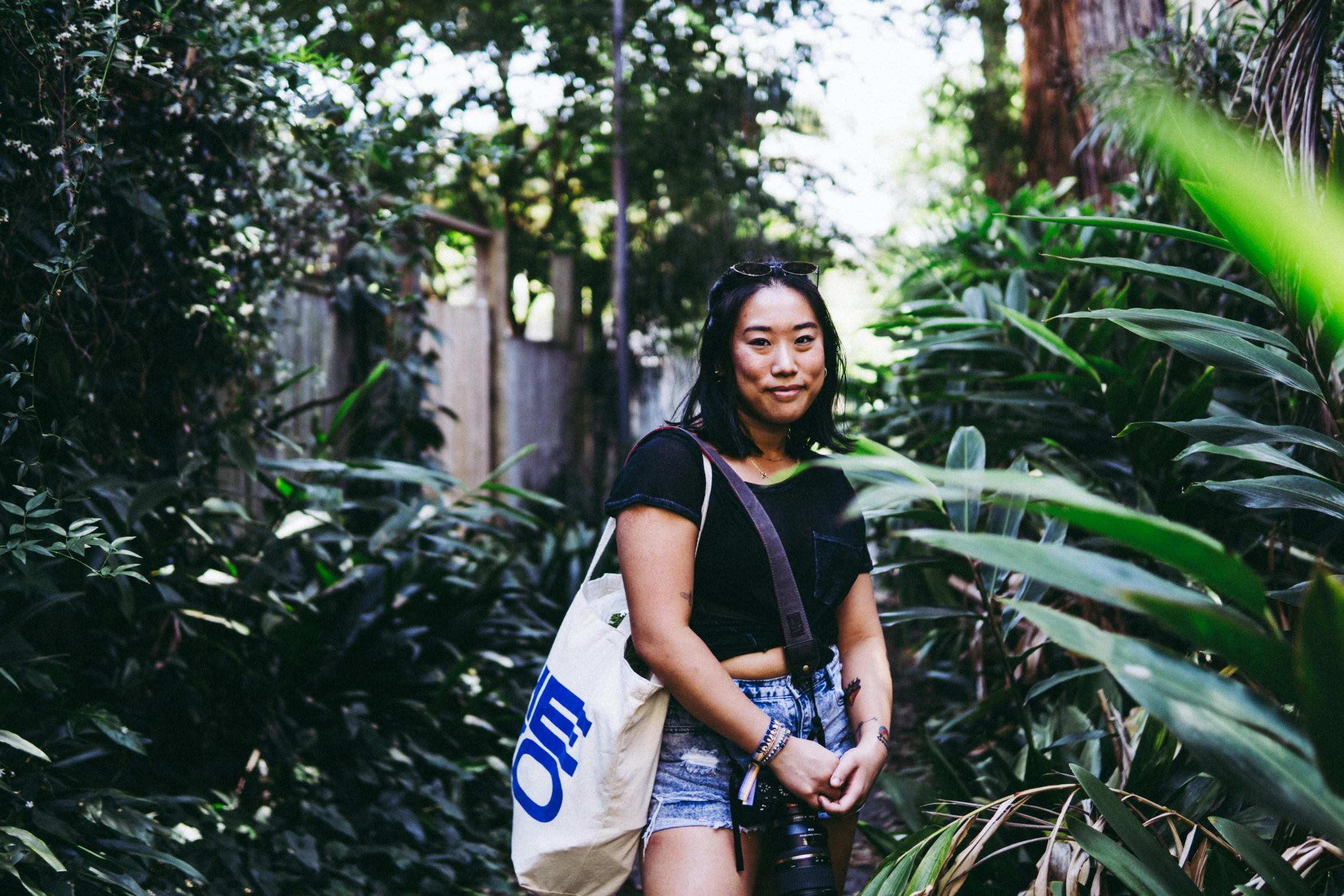 the woman is walking in the forest with a bag