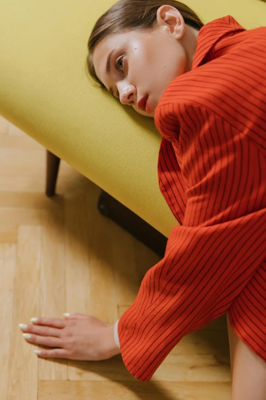 a girl in red shirt hiding behind yellow sofa