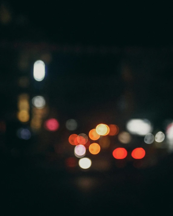 many colorful lights are shining from cars on a street