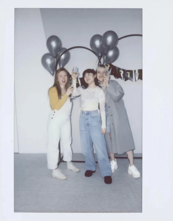 two women are taking a selfie while posing in front of balloons