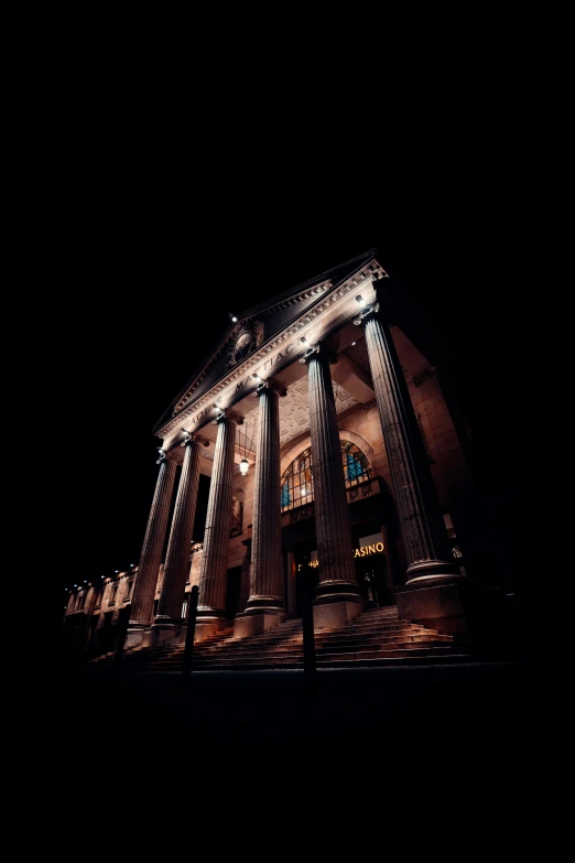 an illuminated building on a street at night