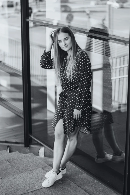 a woman standing outside a building while wearing converses