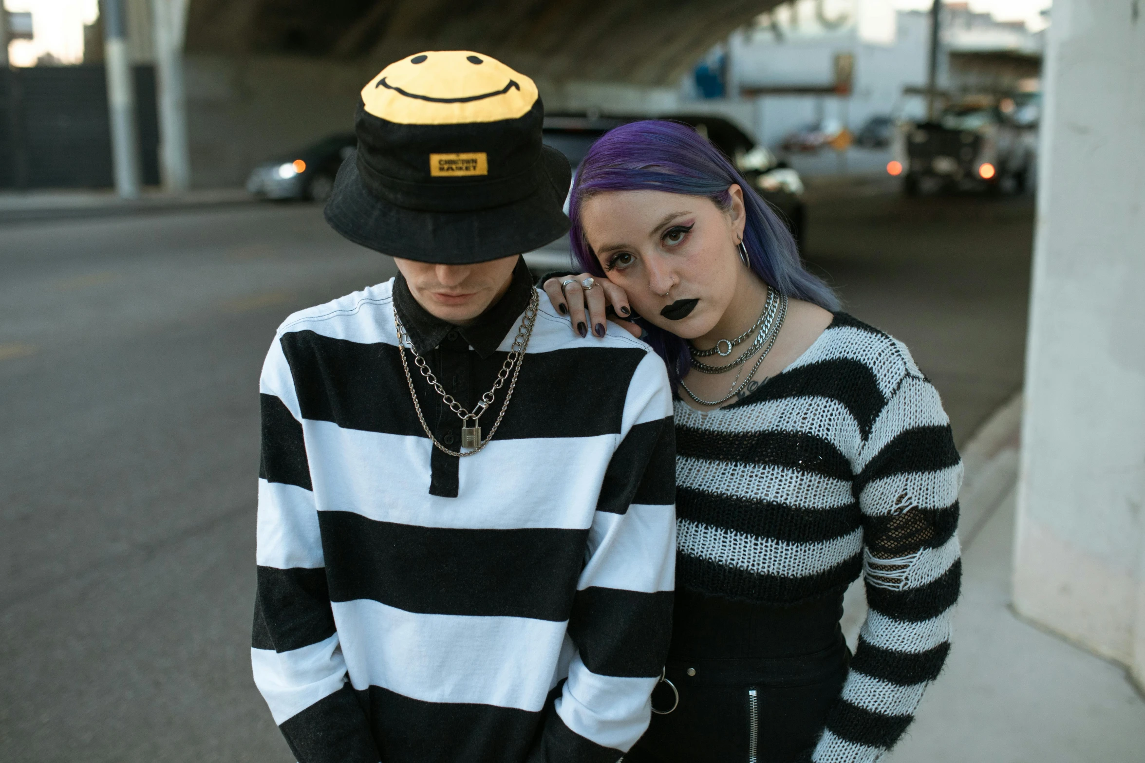 a young couple posing in striped clothing while wearing a hat