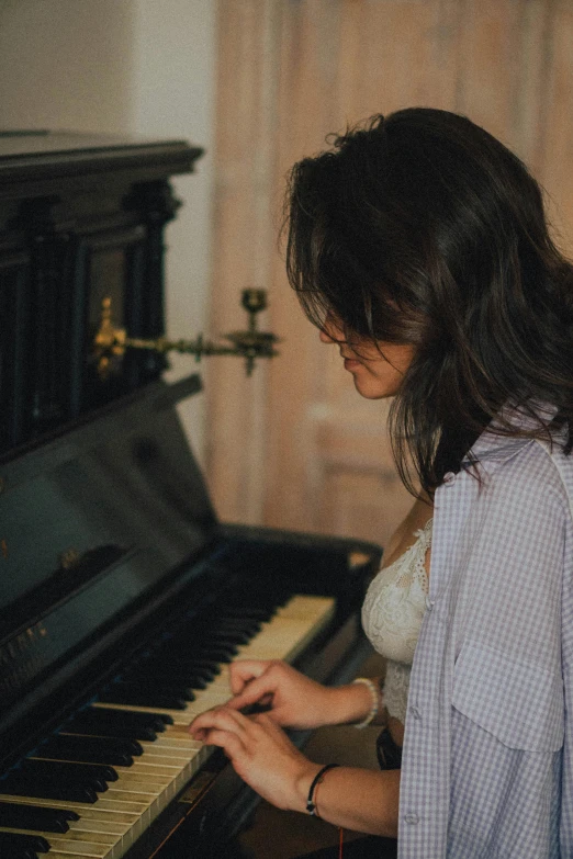 a woman plays the piano in front of a mirror