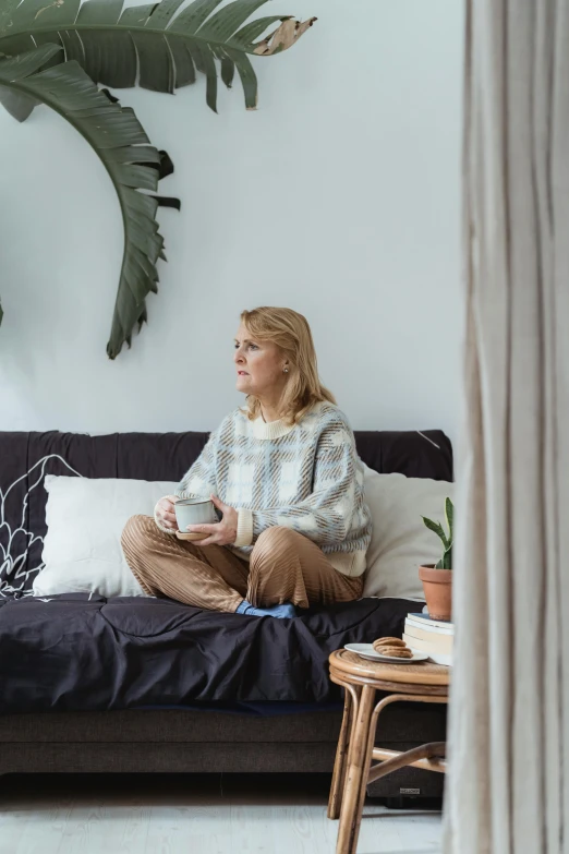 a woman sits on top of a couch