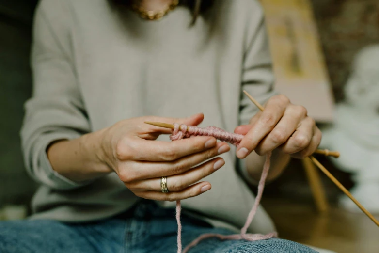 a woman is making her own knitting project