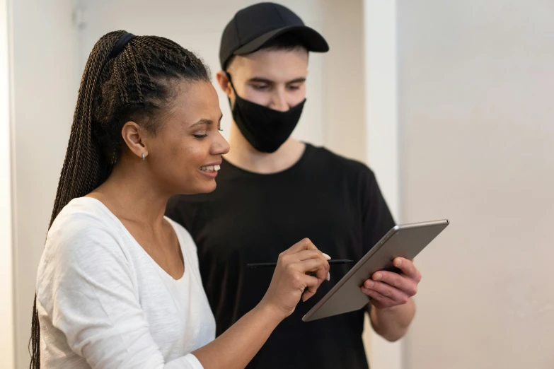 a man and a woman standing together, wearing face masks