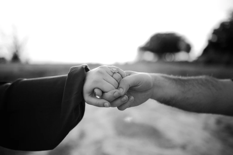 two people holding hands with a blurred background