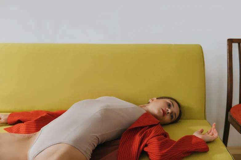 a young woman is lying on the couch in her pajamas