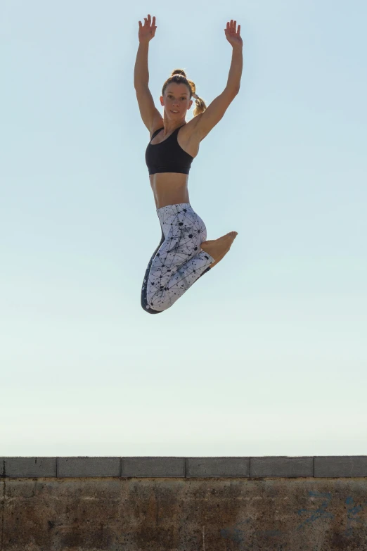 a woman jumping in the air on a skateboard