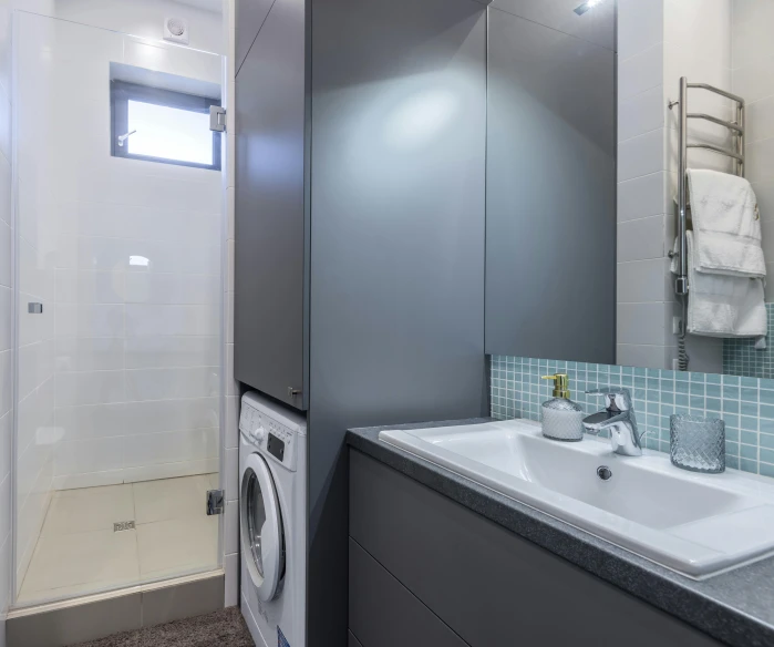 a washer and dryer sit side by side in this small bathroom