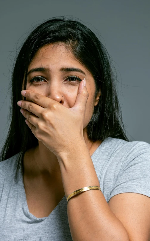 a woman with her hand over her mouth