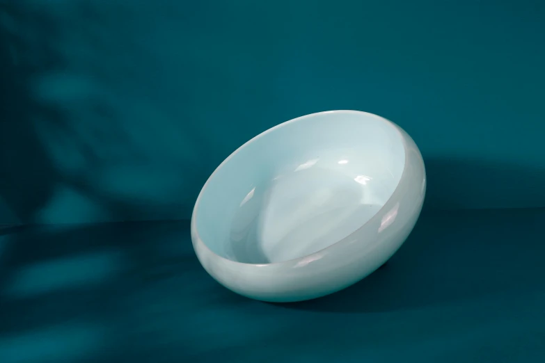 white porcelain bowl on a blue surface with shadow