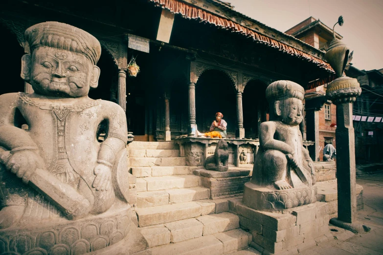 statues in front of an elaborate building with a woman on the other side