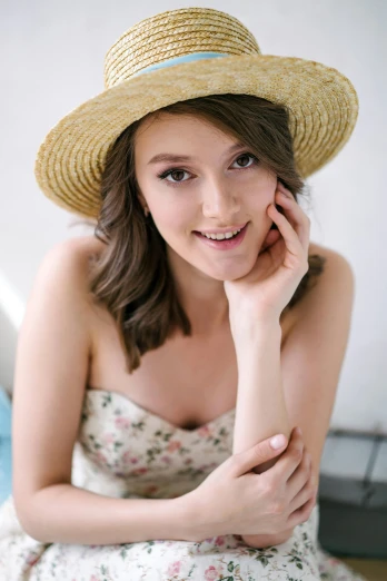a woman posing in a dress and straw hat