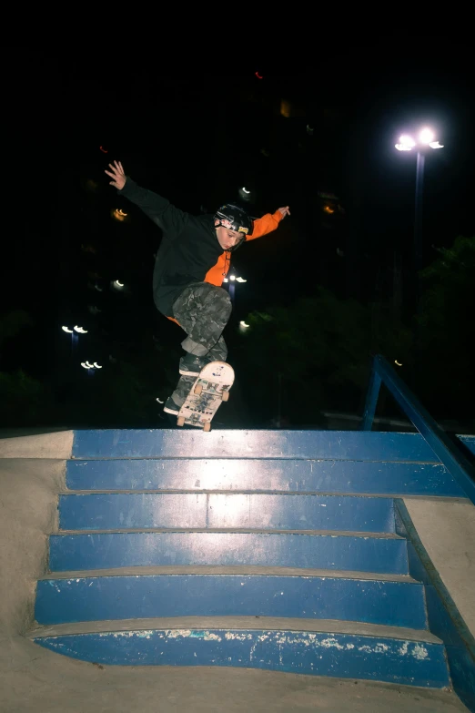 skateboarder grinding on a set of blue hand rails