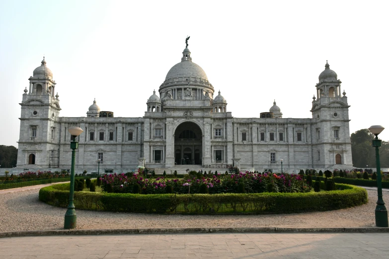 the building has flowers in front and a bird statue in the middle