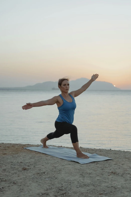 woman doing yoga in front of the ocean