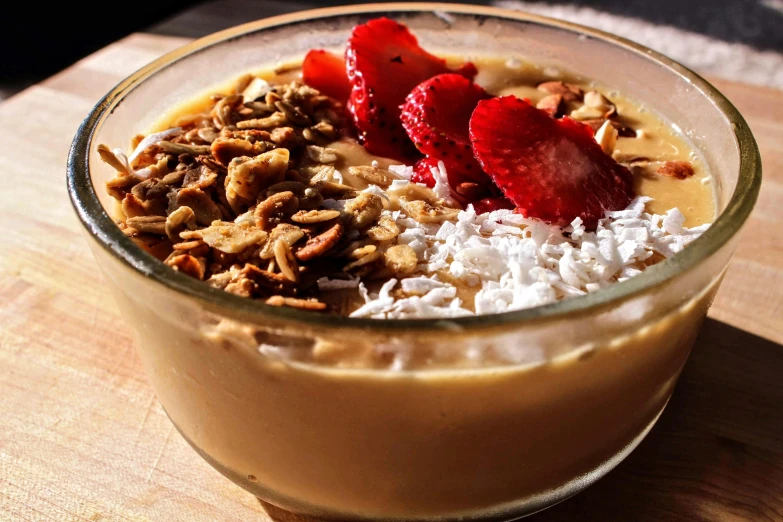 there is a dessert with nuts, strawberries and a cup of coffee