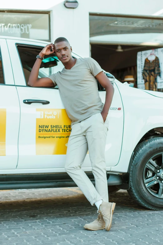 a man in tan pants and tan sneakers standing next to his truck