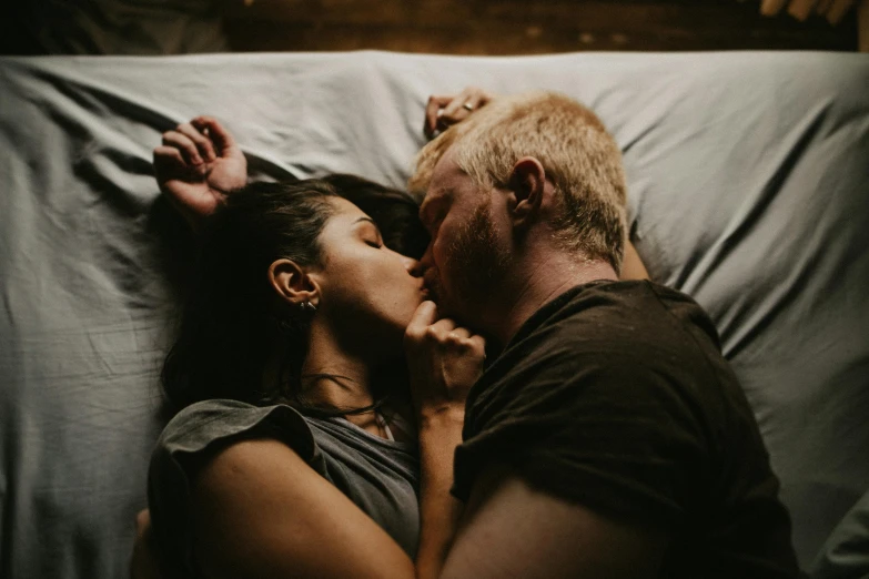 a young man kissing a woman under a white sheet