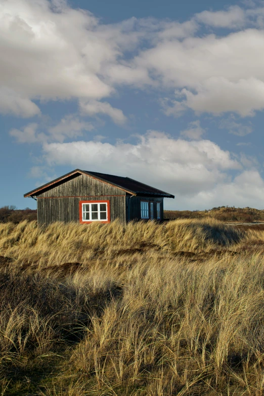 a rustic house in the middle of some grass