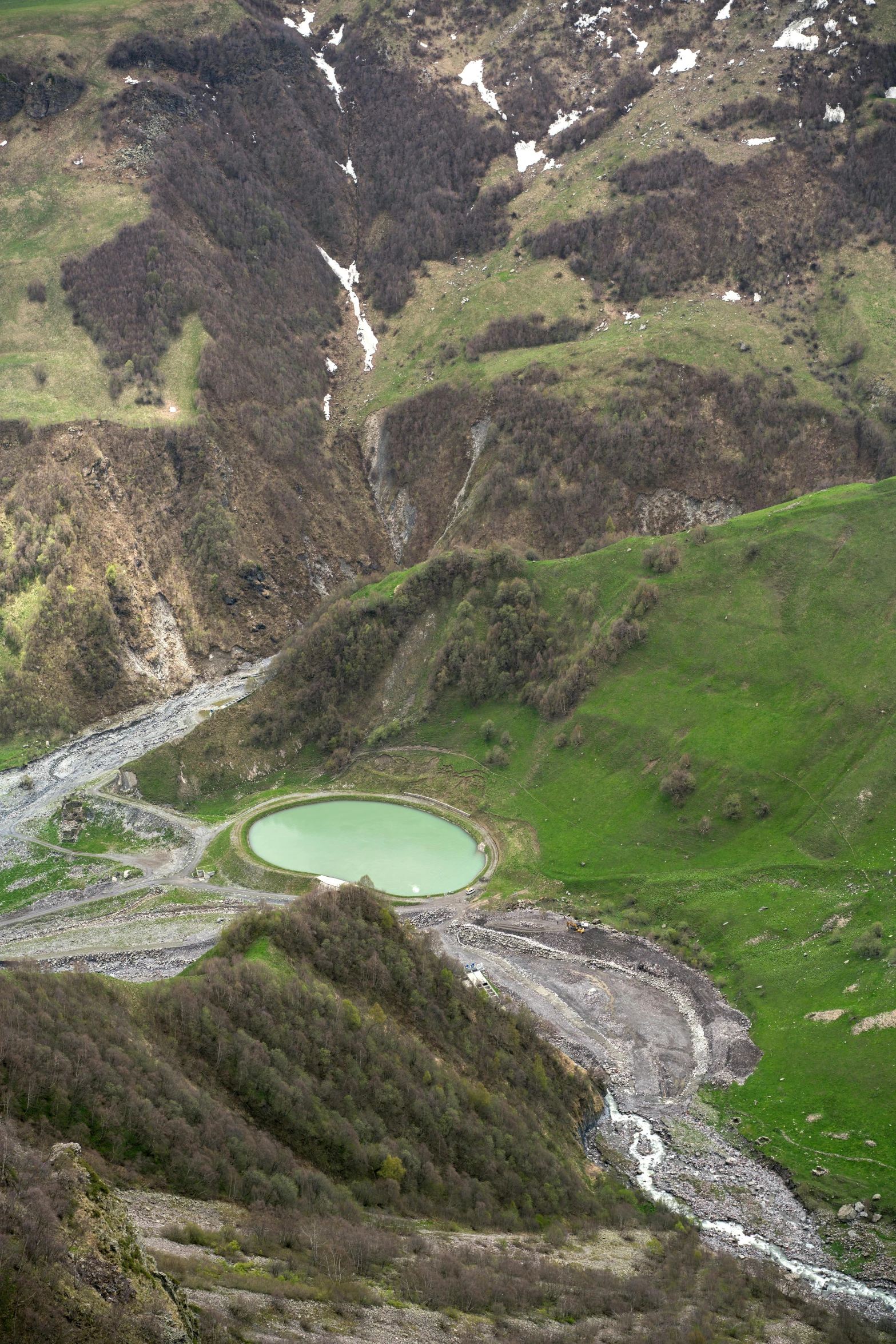 a view of a large river running through a green valley