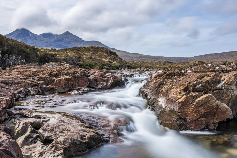 a mountain stream cascades down among some rocky mountains