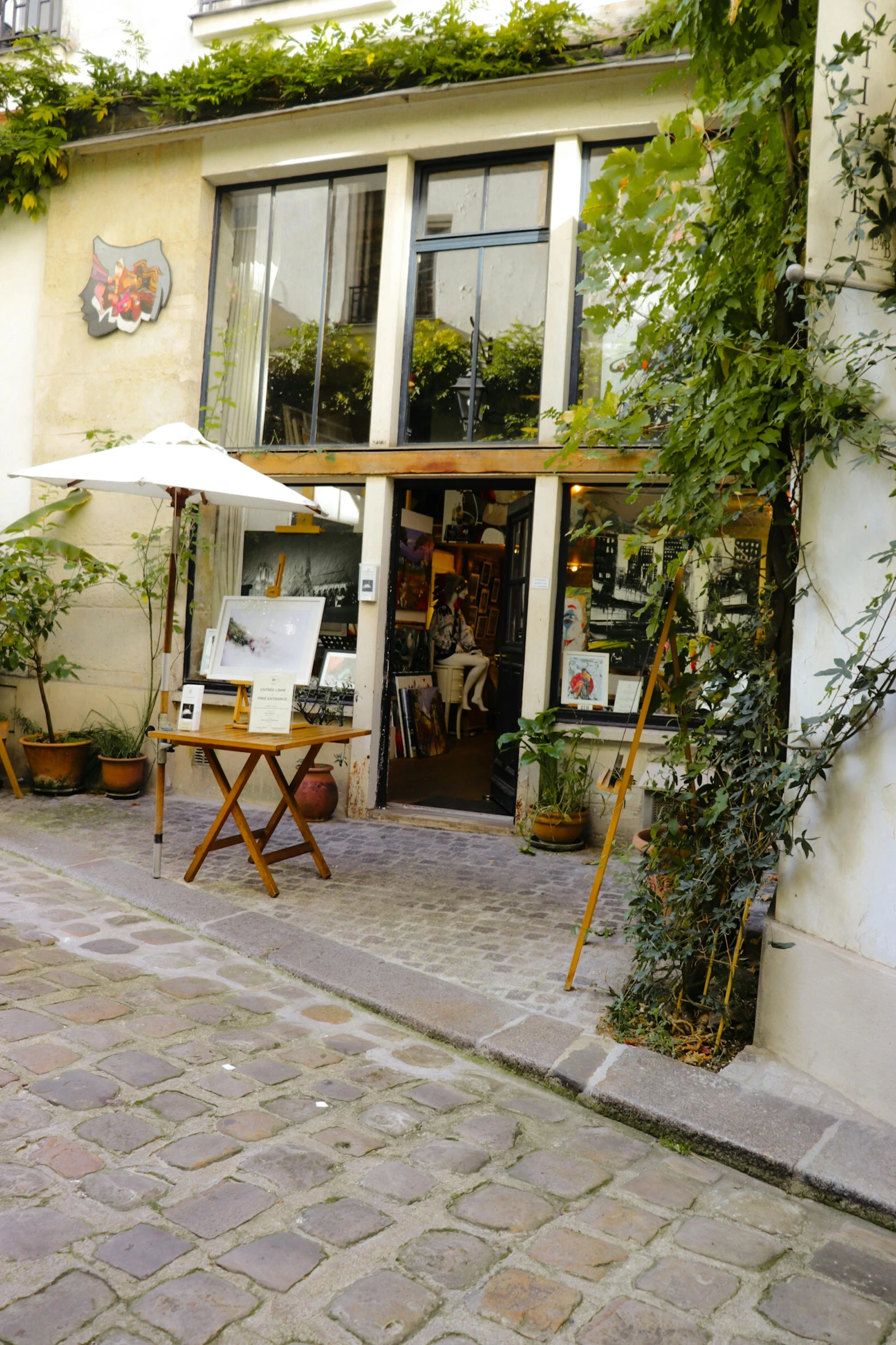 the outside of a building is lined with plants and furniture