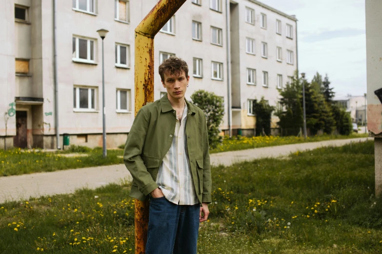 a young man is standing in the middle of some grass