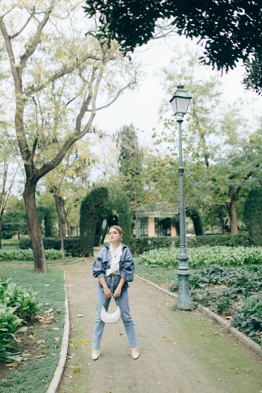 a person standing in front of a lamppost and trees