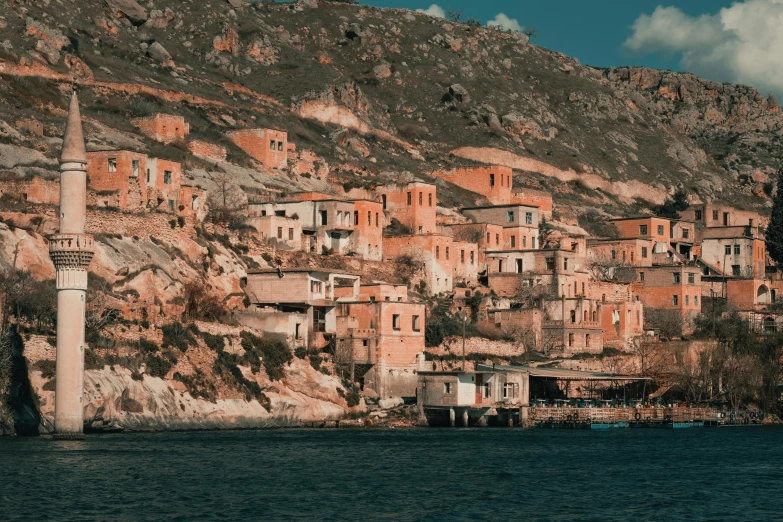 a village is located between the cliff with water below