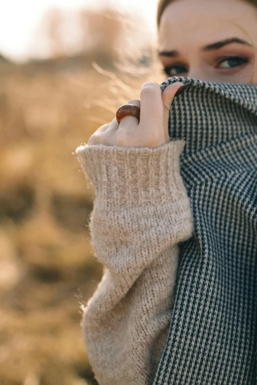 the woman is dressed in sweater and scarf