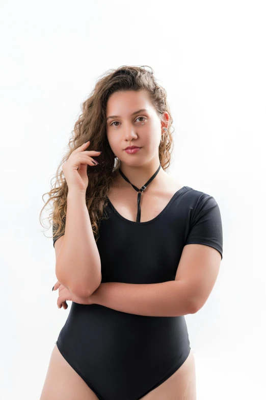 a young lady in a black swimsuit poses for a portrait