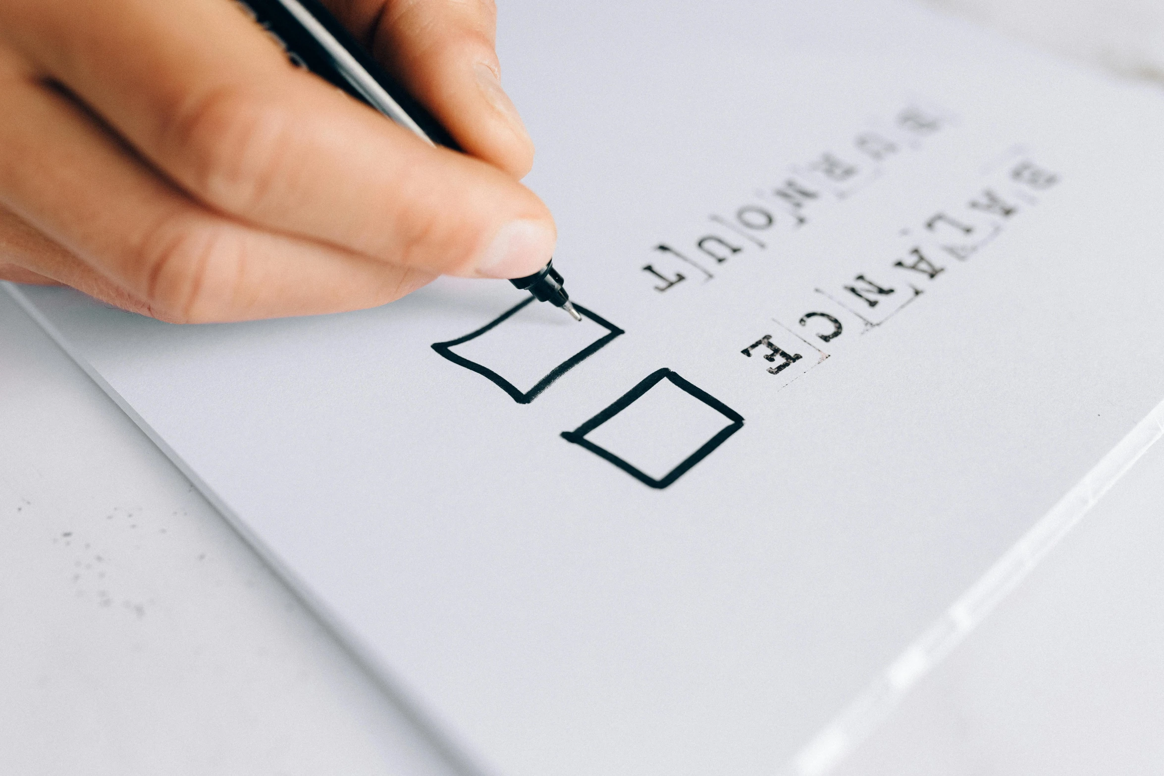 a person writing on a piece of paper