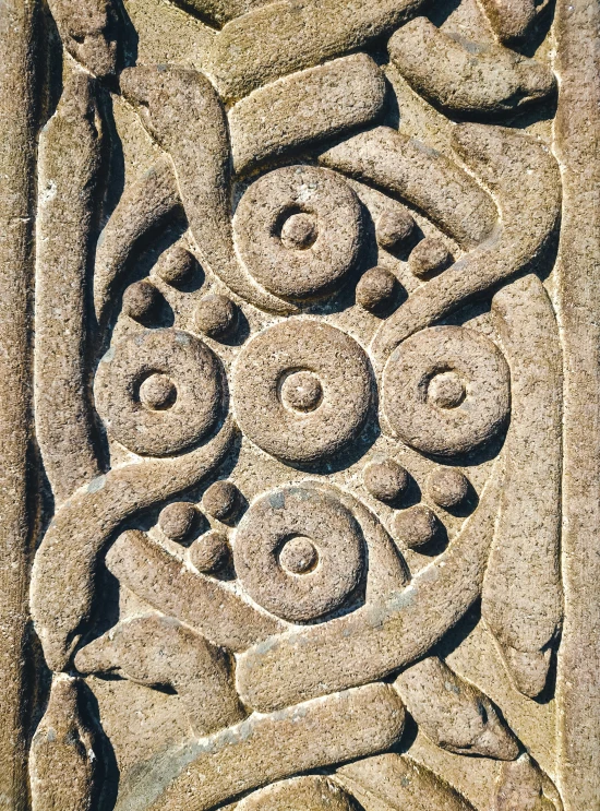 a stone carving of a plant surrounded by other decorative patterns