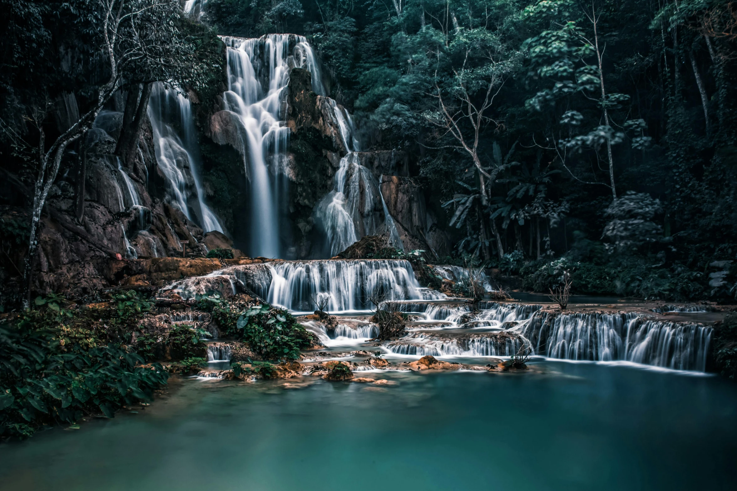 a waterfall and pond with water running through it