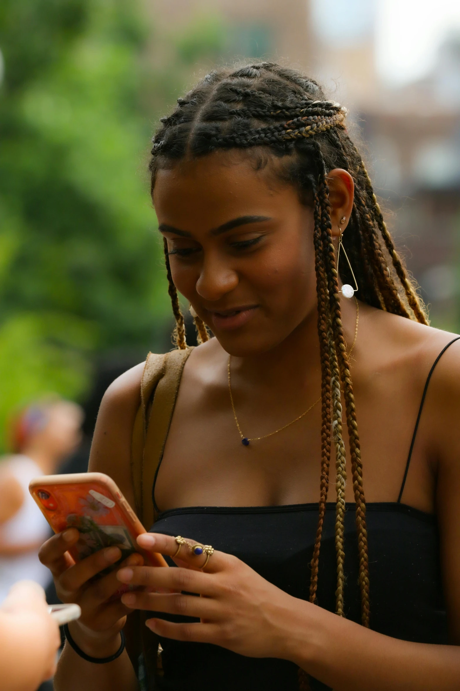 a woman looks at her cell phone on the street